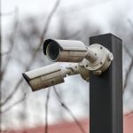 IP CCTV security camera on pole, urban cityscape