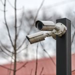 IP CCTV security camera on pole, urban cityscape